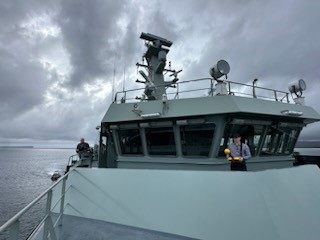 A man is conducting radio wave measurements using a measurement device on a navy ship