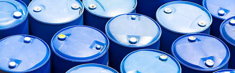 Several blue drums all standing upright in a tight group.